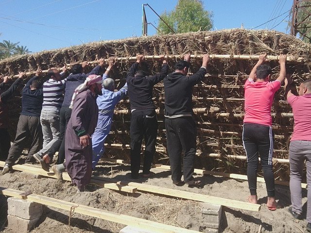 Community members from Hit work together to lift the base of an Isbiya barg - Hit, Iraq (Rashad Salim, Safina Projects, 2019)